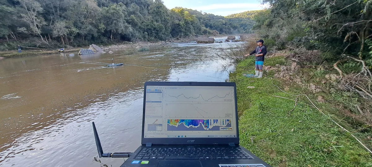 Computador exibindo resultados durante levantamento hidrométrico em um rio